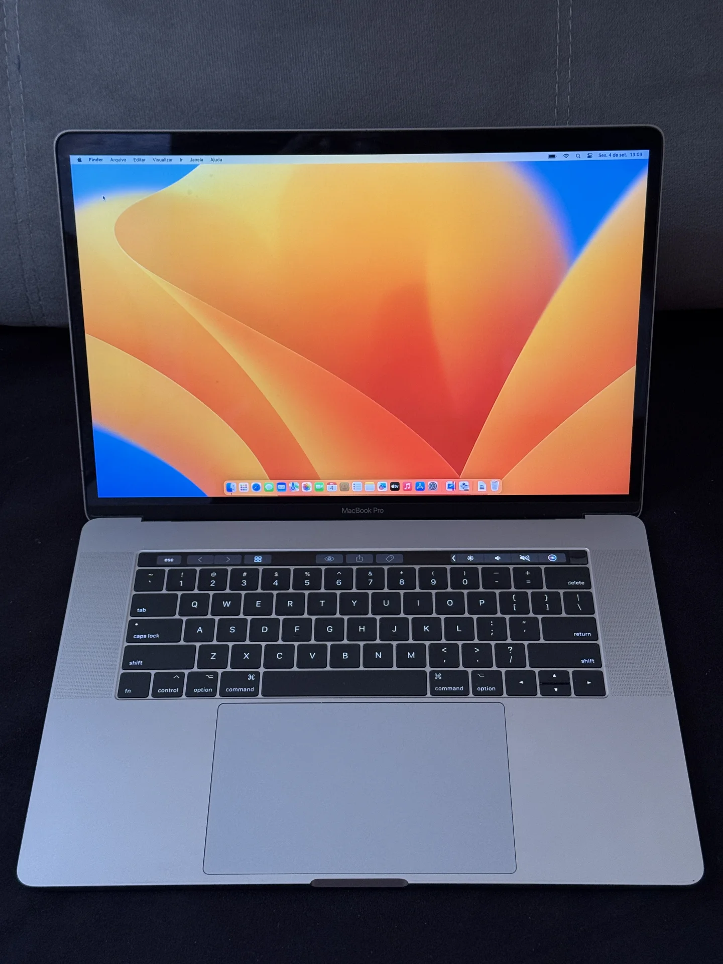 Vista frontal do MacBook Pro aberto, com a tela Retina ligada.