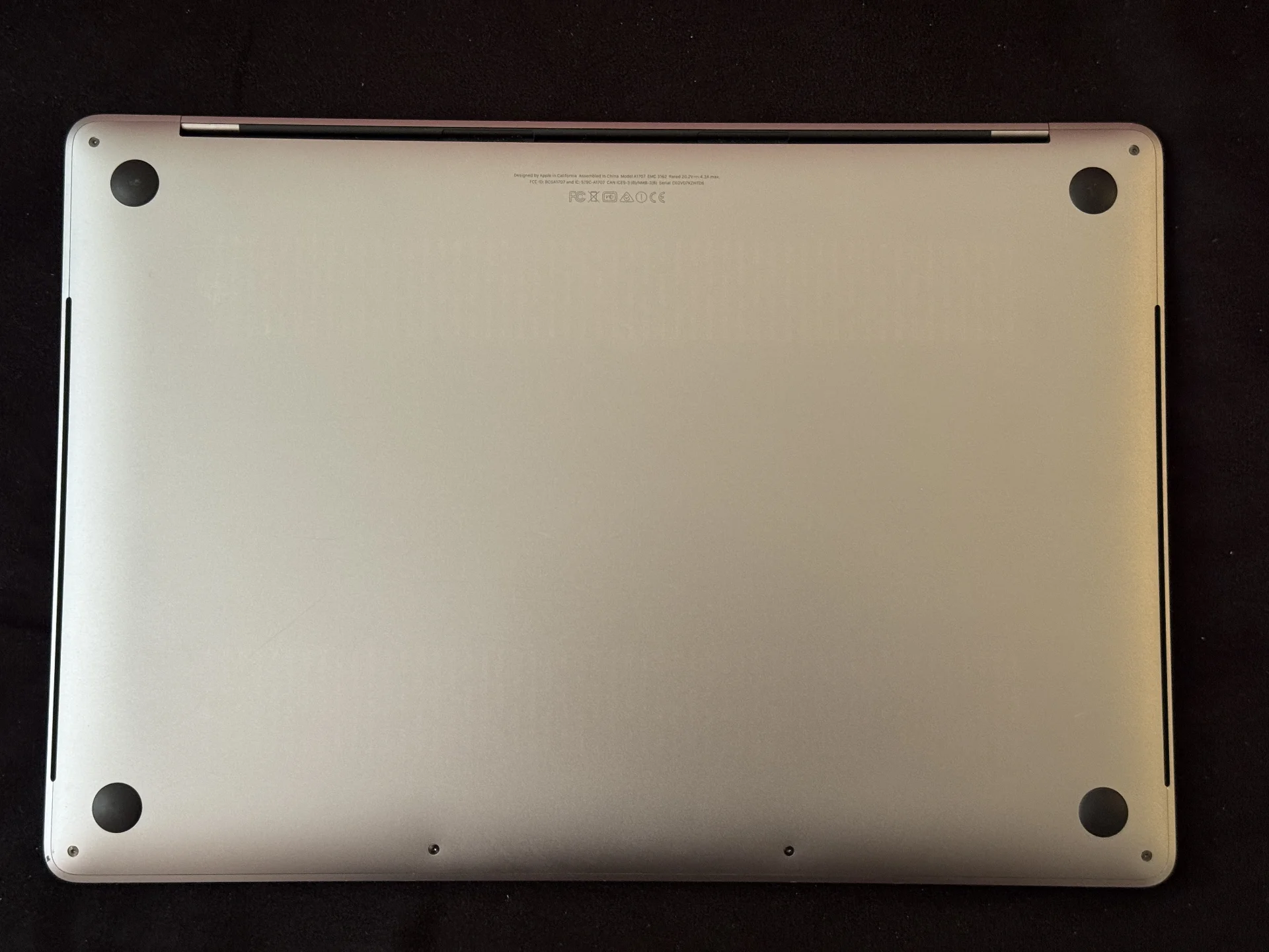 Parte inferior do MacBook Pro, com os quatro apoios visíveis.